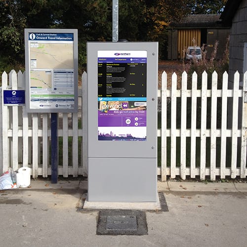 Outdoor digital signage totem showing passenger information at a train station in Cumbria