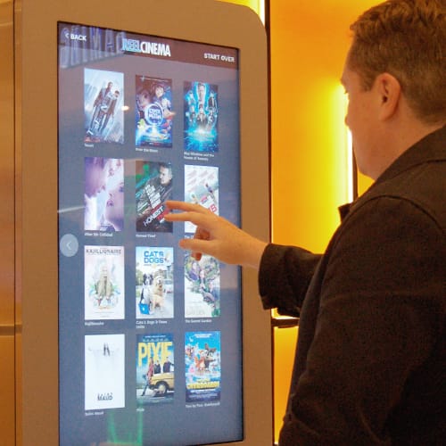Man using touchscreen digital signage at a cinema in Rochdale, Manchester