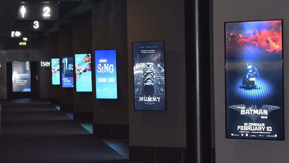 Digital signage screens along a corrridor at a UK cinema
