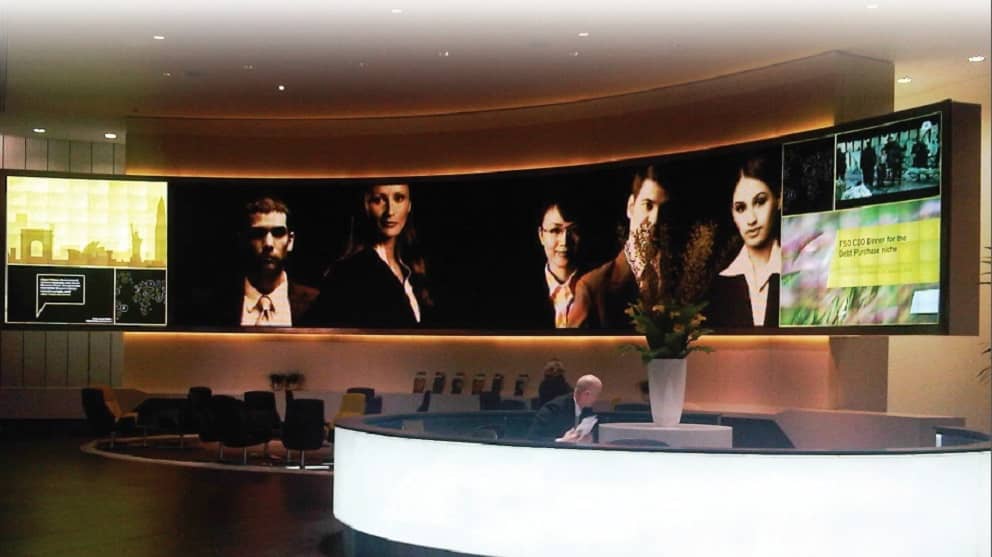 Corporate Digital Signage | Large curved LED wall behind an office reception desk