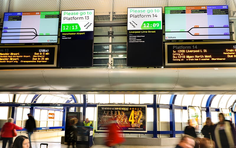 Digital signage screens showing passenger information at Manchester Piccadilly train station