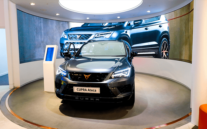 Cupra Ateca in front of a curved LED wall in a car showroom