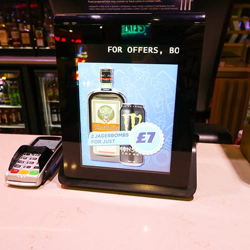 Digital signage in a bar showing drinks promotions