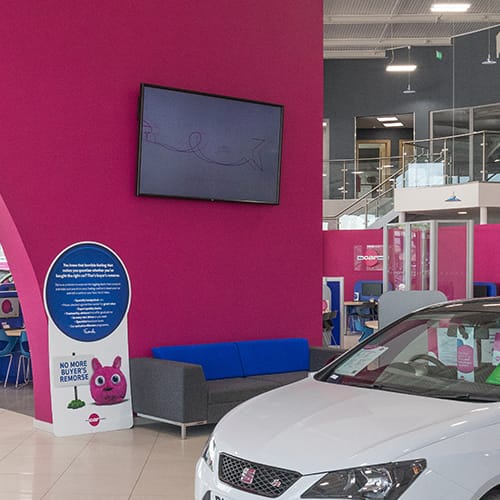 Digital signage screen in a used car supermarket showroom