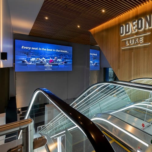 Video wall digital signage at the top of an escalator in an ODEON cinema in London, UK